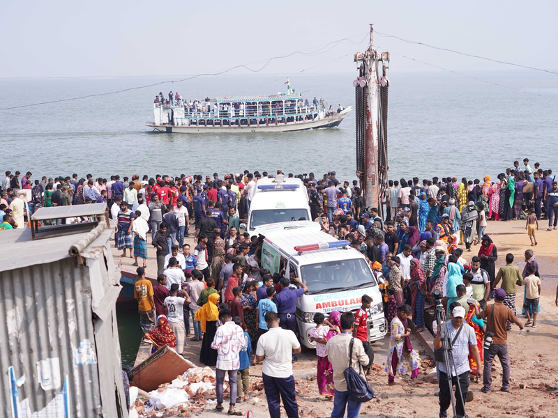 Rettungskräfte und zahlreiche Menschen versammeln sich an einer Unfallstelle, nachdem ein Bus in den Fluss Padma stürzte. - Foto: Rubel Karmaker/ZUMA Press Wire/dpa