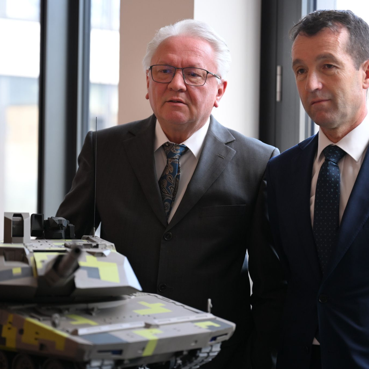 Papperger und Escribano bei einem Modell des Rheinmetall-Kampfpanzers Panther. - Foto: Wolf von Dewitz/dpa