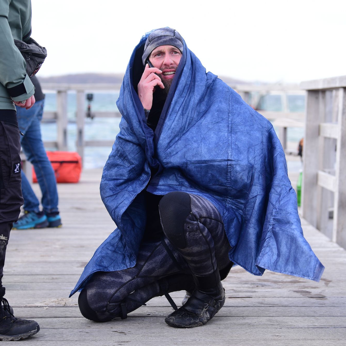Robert Marc Lehmann geht auf Tuchfühlung mit einem gestrandeten Wal in der Ostsee.  - Foto: Daniel Bockwoldt/dpa