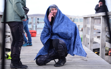 Robert Marc Lehmann geht auf Tuchfühlung mit einem gestrandeten Wal in der Ostsee. - Foto: Daniel Bockwoldt/dpa