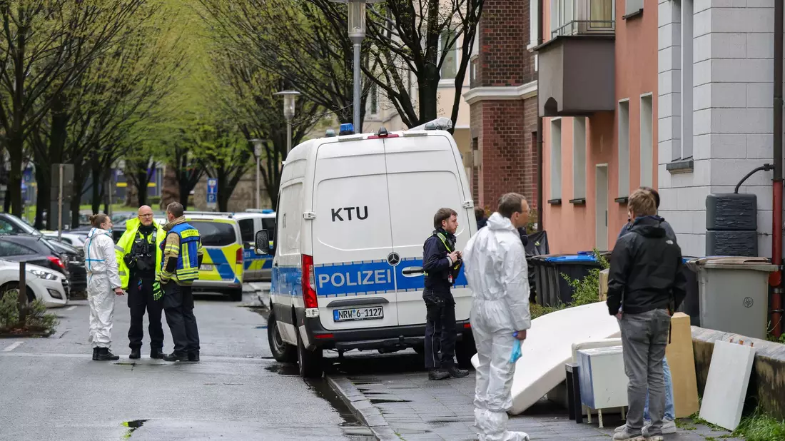 Polizeibeamte vor dem Mehrfamilienhaus der Familie in Witten. Mutter und Tochter sind weiterhin im Krankenhaus. - Bild: Christoph Reichwein/dpa