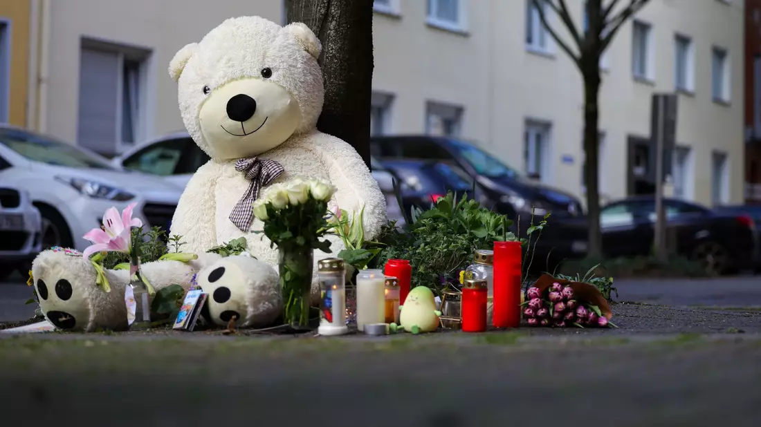 Vor dem Wohnhaus der Familie sind inzwischen Kerzen, Blumen und ein großer Teddybär abgelegt worden. - Bild: Christoph Reichwein/dpa