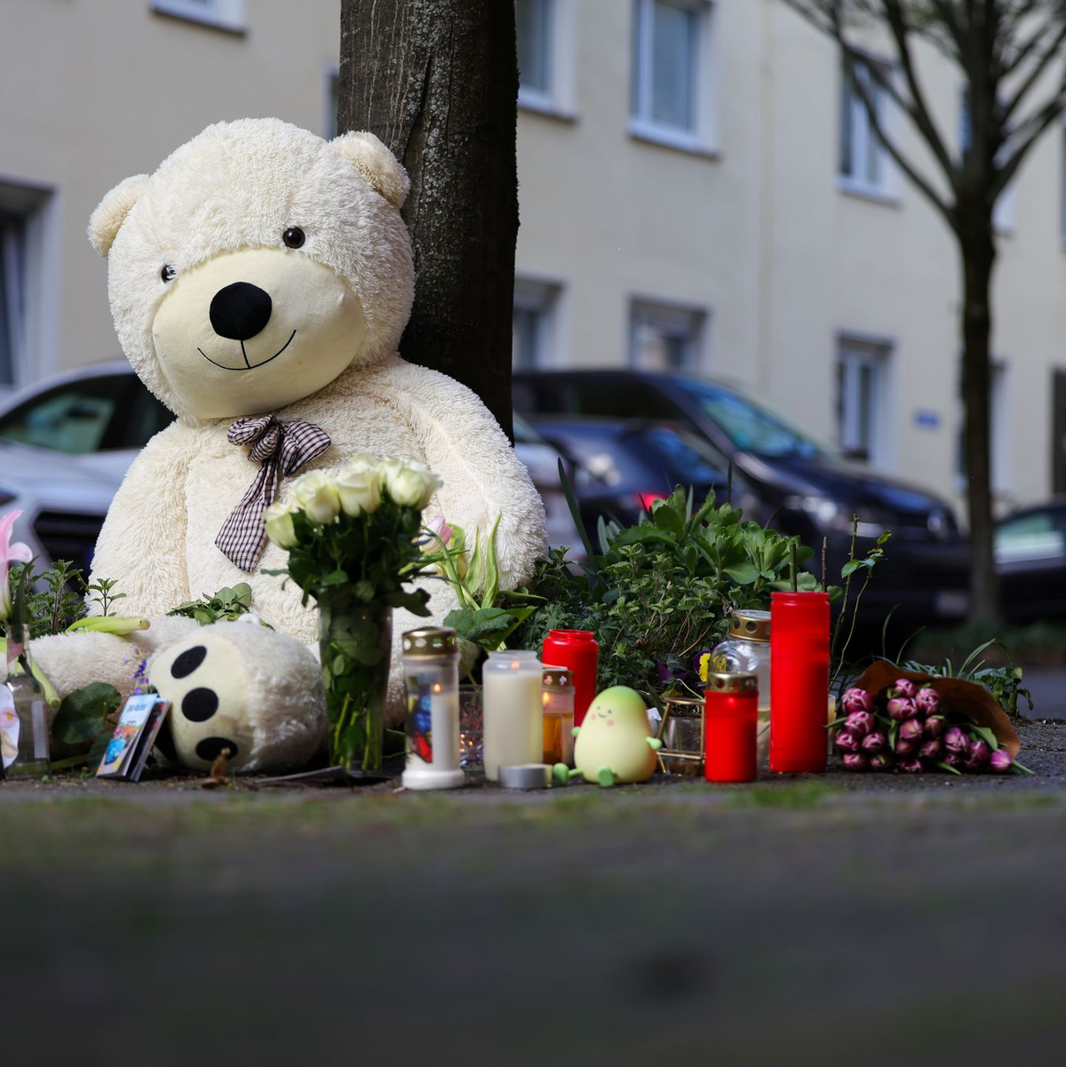 Vor dem Wohnhaus der Familie sind inzwischen Kerzen, Blumen und ein großer Teddybär abgelegt worden. - Foto: Christoph Reichwein/dpa