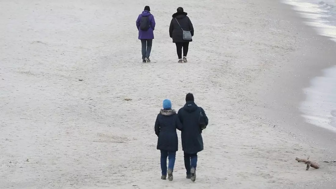 Paare gehen am Strand spazieren - Bild: via dts Nachrichtenagentur