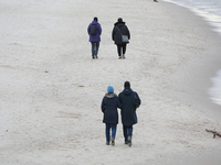 Paare gehen am Strand spazieren - Foto: via dts Nachrichtenagentur