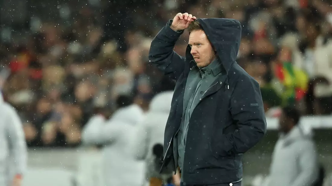 Julian Nagelsmann zieht sich im Regen eine Kapuze über den Kopf. - Bild: Christian Charisius/dpa