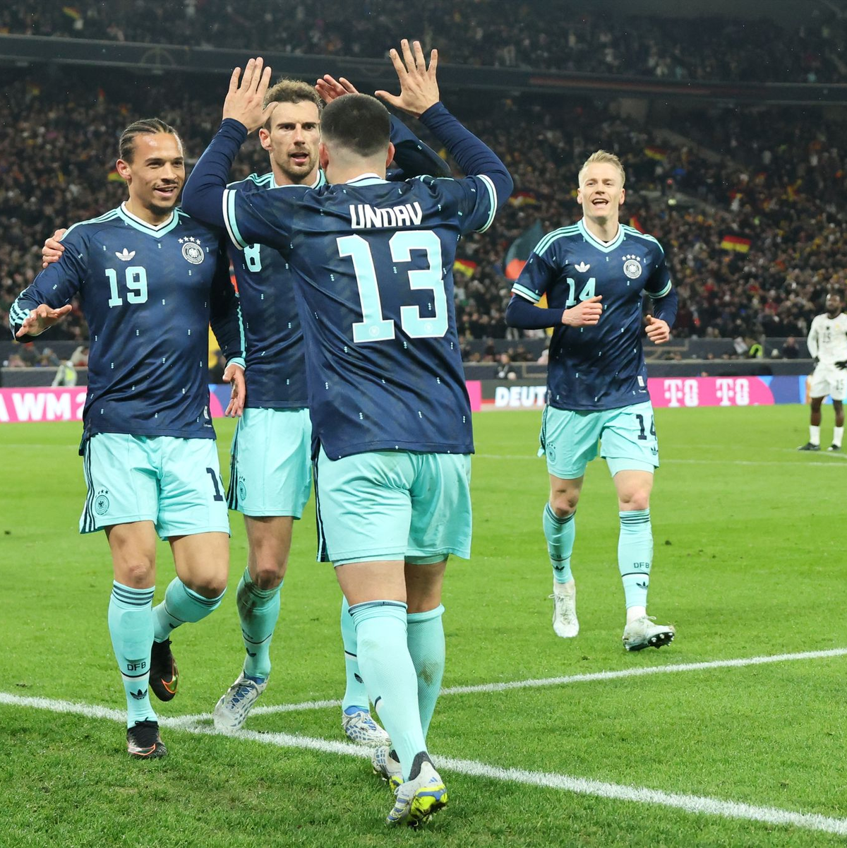 Leroy Sané (l) jubelt mit Leon Goretzka und Torschütze Deniz Undav nach dem späten Siegtor gegen Ghana. - Foto: Christian Charisius/dpa
