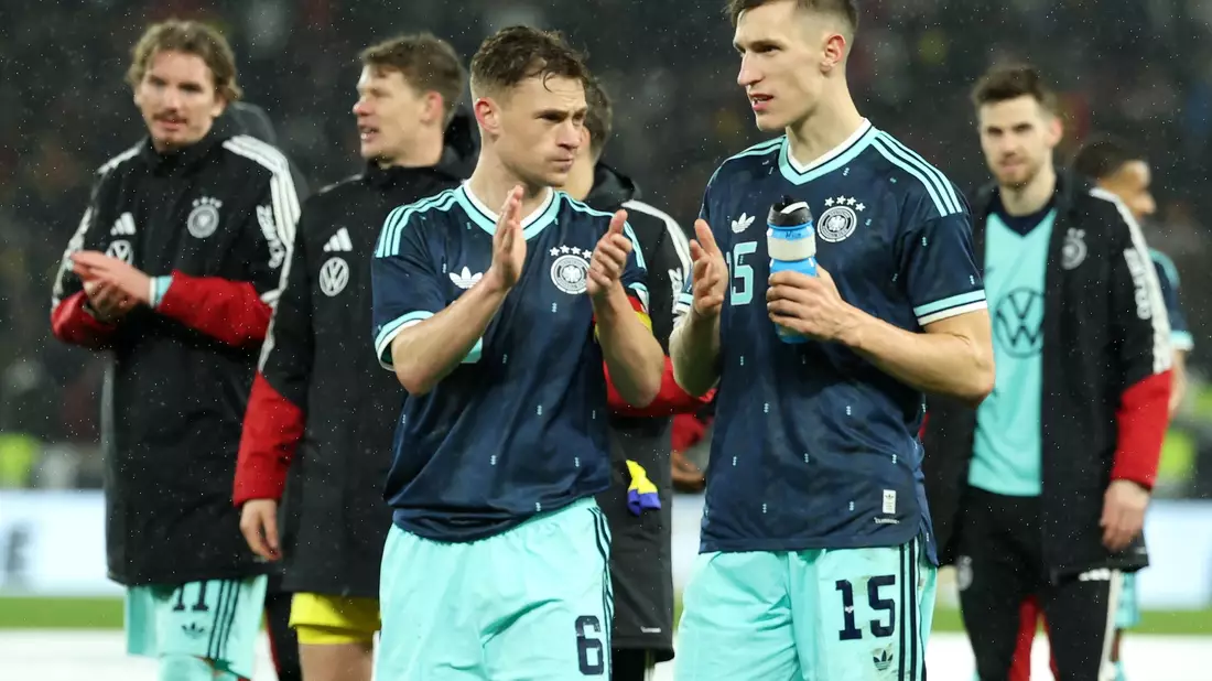 Nico Schlotterbeck (r.) spricht auf dem Platz mit DFB-Kapitän Joshua Kimmich.  - Bild: Christian Charisius/dpa