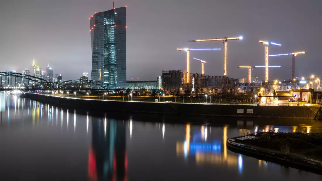 Die Bankenskyline von Frankfurt ragt hinter der Europäischen Zentralbank (EZB)  empor. - Bild: Boris Roessler/dpa