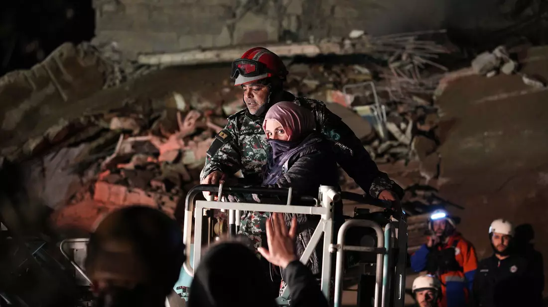 Eine Frau, die nach einem israelischen Luftangriff aus einem zerstörten Gebäude in Beirut gerettet wird.  - Bild: Emilio Morenatti/AP/dpa