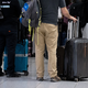 Passagiere stehen am Münchner Flughafen mit ihrem Gepäck an einem Check-in-Schalter. - Foto: Sven Hoppe/dpa