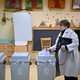 Eine Frau gibt am Morgen ihre Stimme in einem Wahllokal in Budapest ab. - Foto: Denes Erdos/AP/dpa