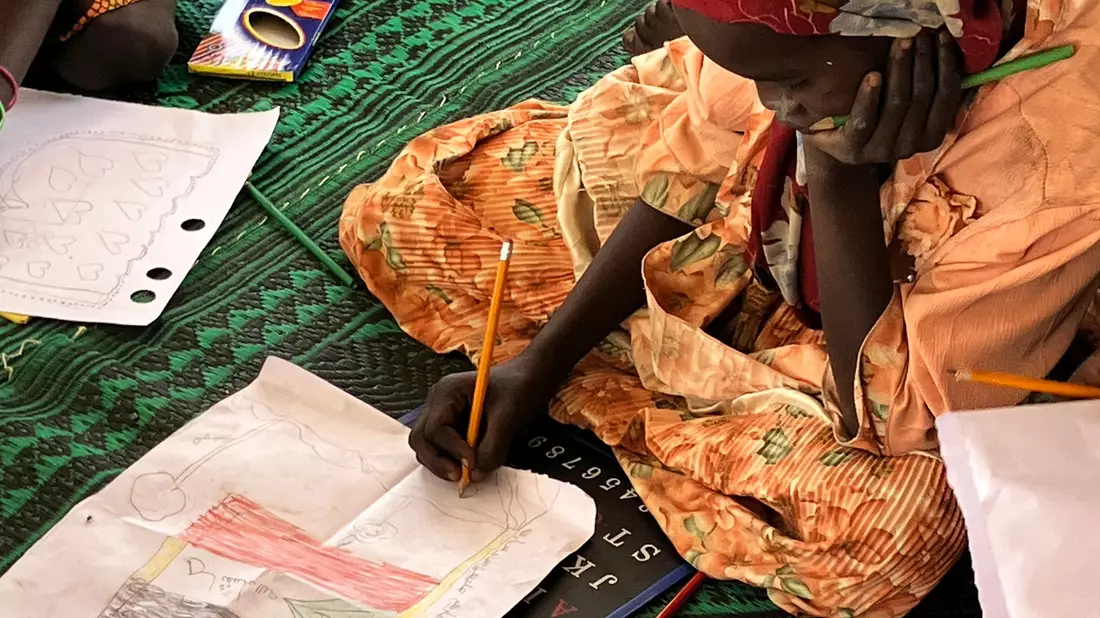 Ein kleines Mädchen malt die sudanesische Flagge. - Bild: Eva Krafczyk/dpa