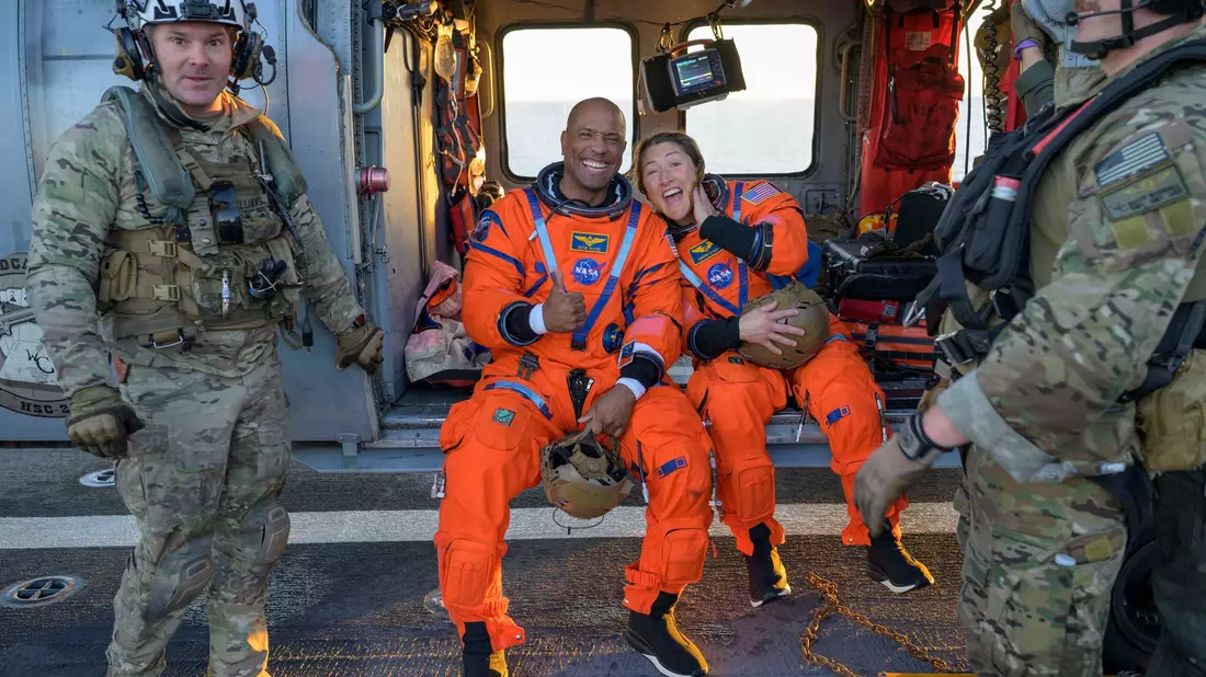 Die Astronauten Victor Glover und Christina Koch sitzen auf einem Hubschrauber der Navy auf dem Flugdeck des Schiffs USS John P. Murtha, nachdem sie aus ihrem «Orion»-Raumschiff geholt wurden. - Bild: Bill Ingalls/NASA/AP/dpa