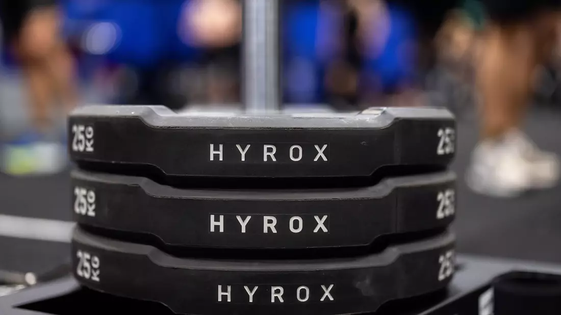 Hantelscheiben mit dem Schriftzug Hyrox an einem Messestand, wo wenig später ein Lauf- und Workout-Wettbewerb stattfinden sollte. - Bild: Rolf Vennenbernd/dpa
