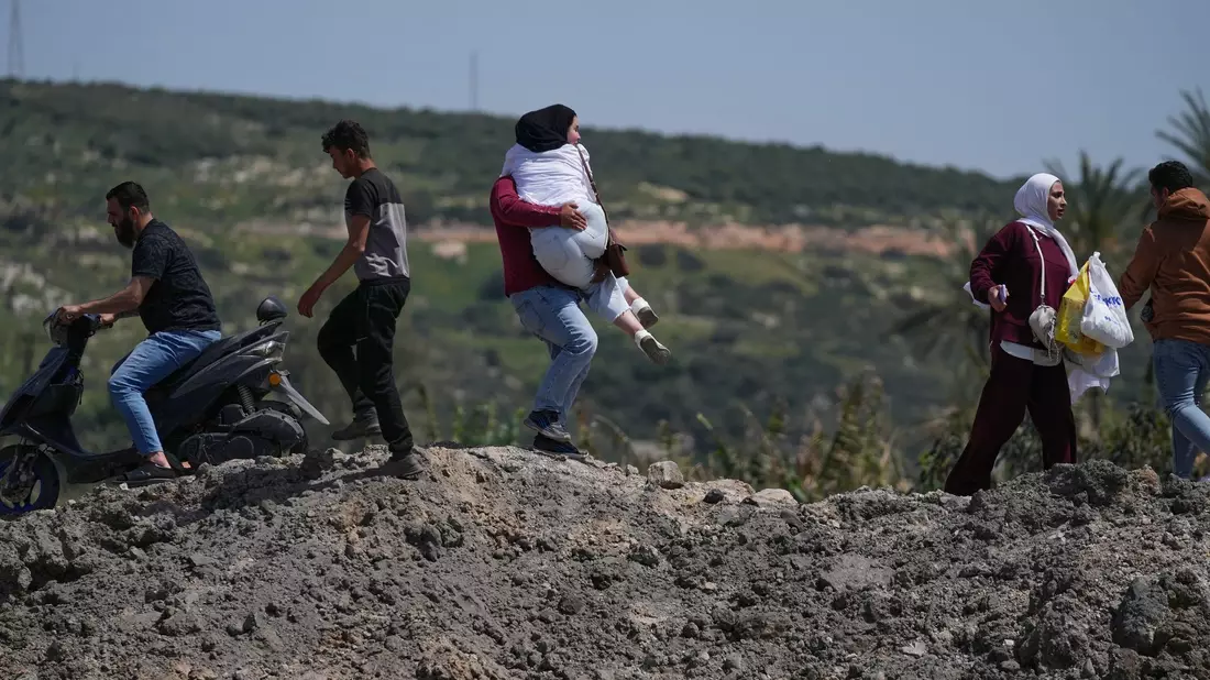 Menschen an einer zerstörten Brücke im Südlibanon. - Bild: Mohammed Zaatari/AP/dpa
