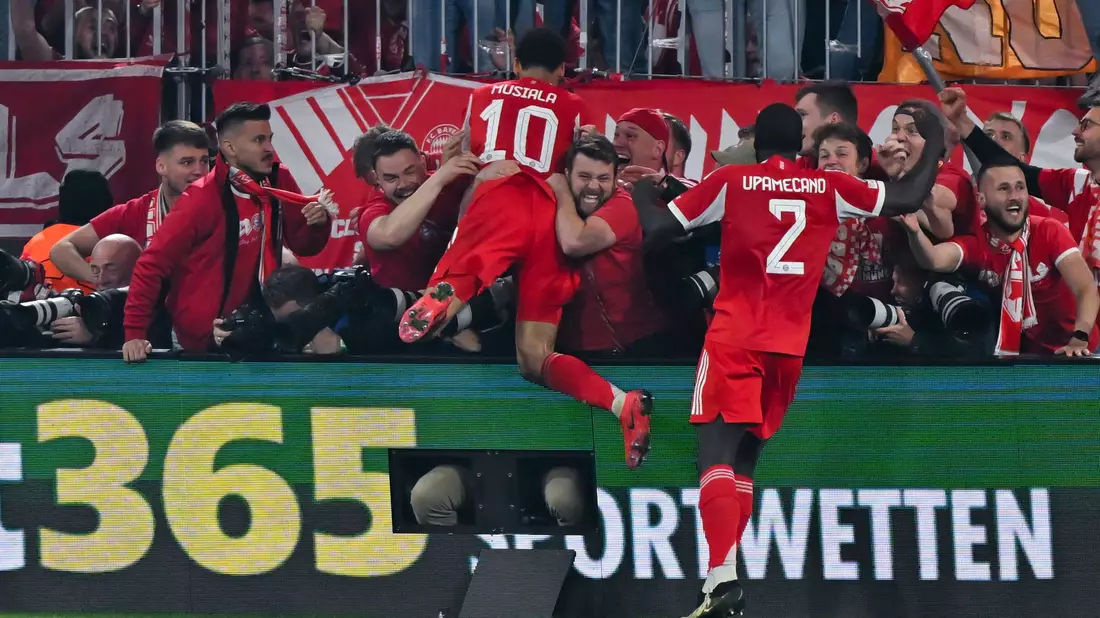 Nach dem letzten Bayern-Tor gegen Real springen einige Münchner Fans und Bayern-Profi Jamal Musiala im Jubel den anwesenden Fotografen in den Rücken. - Bild: Sven Hoppe/dpa