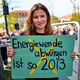 Luisa Neubauer hält ein Schild mit der Aufschrift «Energiewende abwürgen ist so 2013» in der Hand.  - Foto: Michael Ukas/dpa