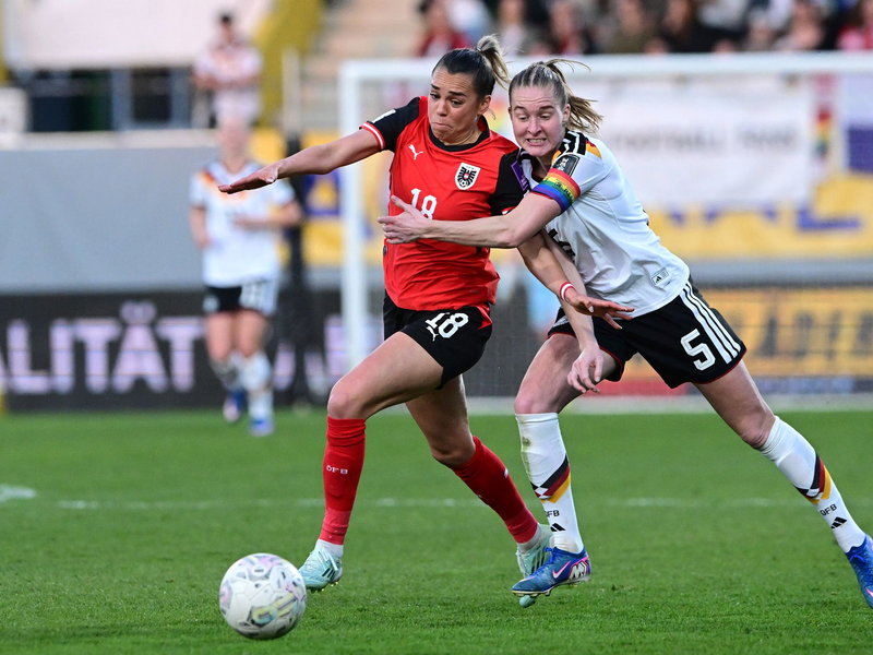 DFB-Kapitänin Janina Minge (r) weiß sich nur mit einer Notbremse gegen Julia Hickelsberger zu helfen.  - Foto: Expa/ Reinhard Eisenbauer/APA/dpa