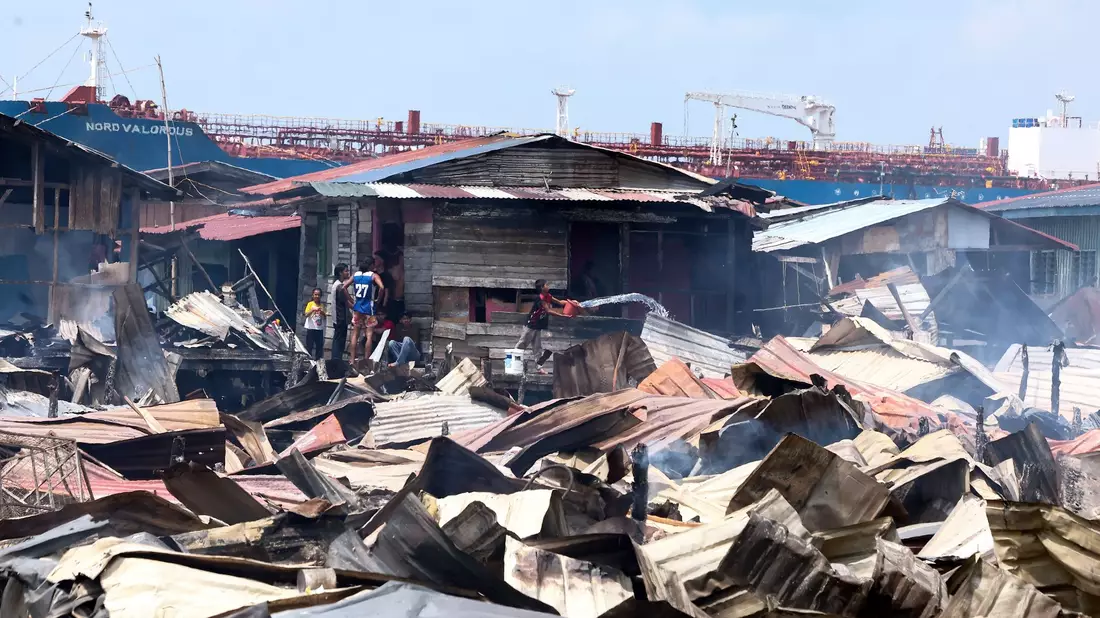 Die Löscharbeiten wurden nach Angaben von Einsatzkräften durch enge Zufahrten, starken Wind und eingeschränkten Zugang zu Wasser bei Ebbe erschwert. - Bild: Bernama/Handout/XinHua/dpa