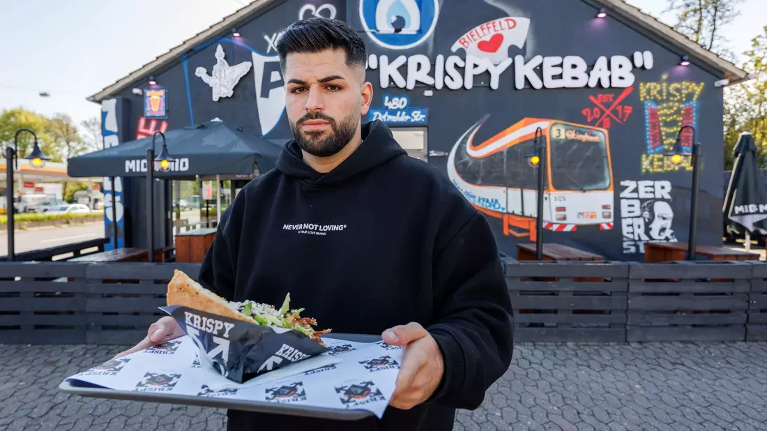 Dönerketten-Chef Sergen Kolcu vor einer seiner Filialen in Bielefeld. - Bild: Friso Gentsch/dpa