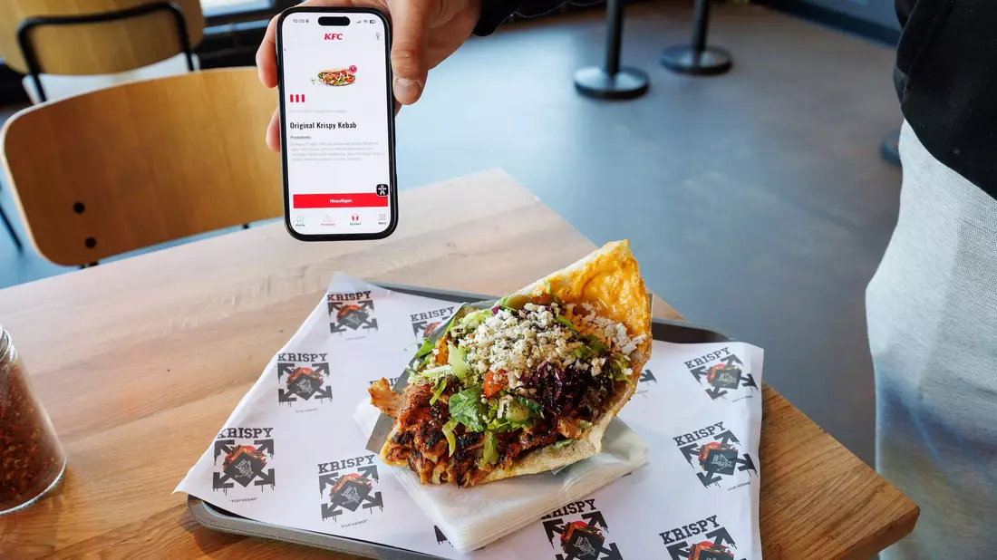 Zwei Mal Krispy Kebab: einmal auf dem Smartphone in der KFC-App und einmal auf einem Tablett in einer Krispy-Kebab-Filiale. - Bild: Friso Gentsch/dpa