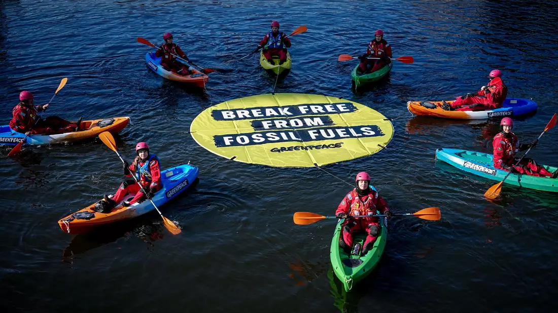 Greenpeace fordert bei einer Aktion am Veranstaltungsort die Abkehr von fossilen Energien. - Bild: Kay Nietfeld/dpa
