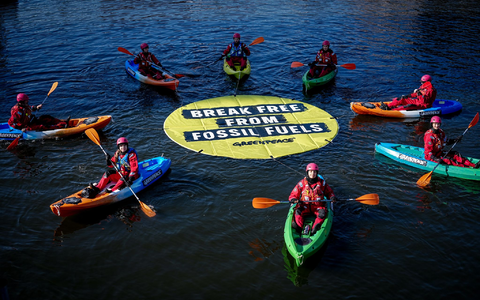 Greenpeace fordert bei einer Aktion am Veranstaltungsort die Abkehr von fossilen Energien. - Foto: Kay Nietfeld/dpa