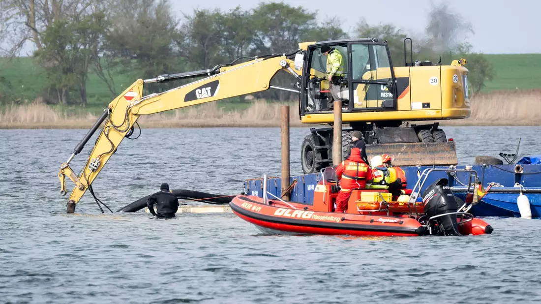 Helfer einer privaten Initiative wollen eine Rinne vom Liegeplatz des gestrandeten Wals zum tiefen Fahrwasser graben.  - Bild: Philip Dulian/dpa