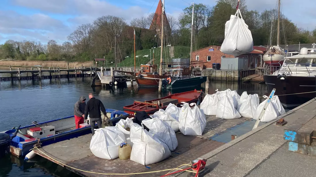Mit Sand gefüllte Big Bags werden im Hafen von Kirchdorf auf der Insel Poel auf eine schwimmende Plattform verladen.  - Bild: Helmut Reuter/dpa