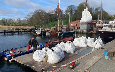 Mit Sand gefüllte Big Bags werden im Hafen von Kirchdorf auf der Insel Poel auf eine schwimmende Plattform verladen.  - Foto: Helmut Reuter/dpa