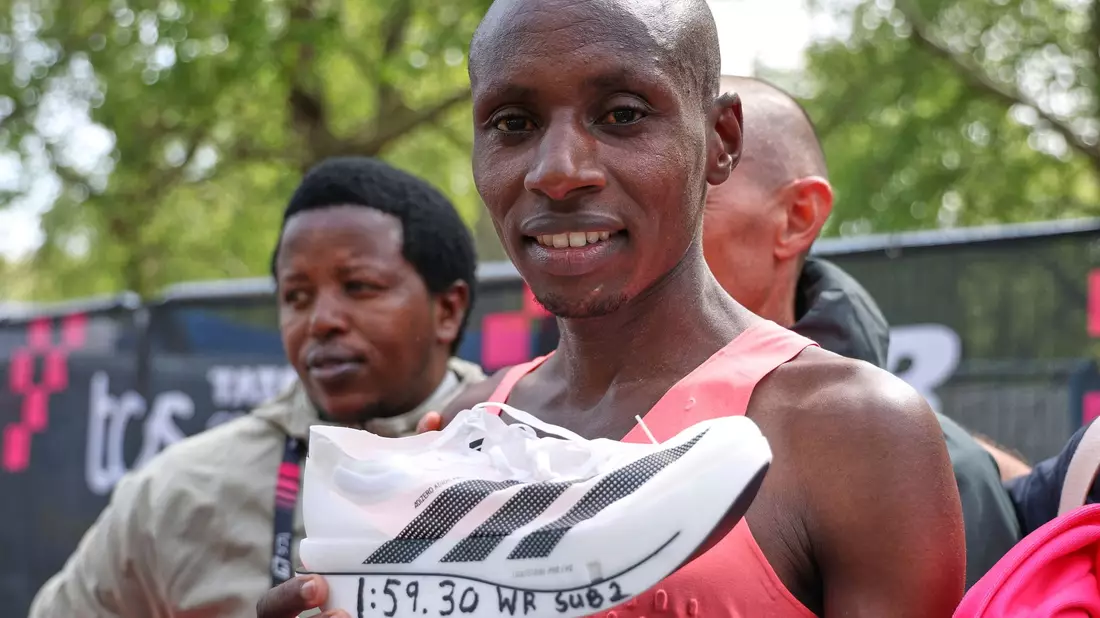 Posierte im Ziel mit einem Schuh: Sabastian Sawe. - Bild: Ian Walton/AP/dpa