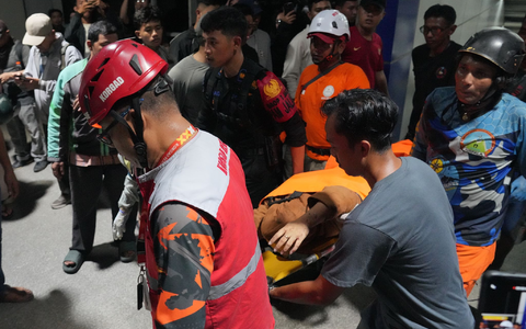Retter tragen eine Frau auf einer Trage. - Foto: Ahmad Ibrahim/AP/dpa