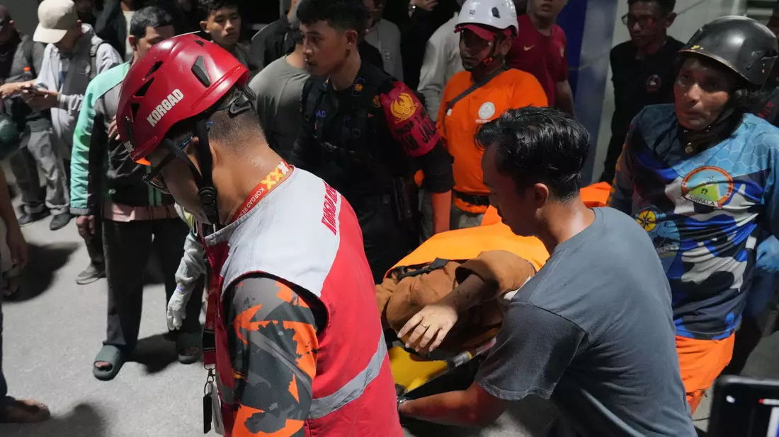 Retter tragen eine Frau auf einer Trage. - Bild: Ahmad Ibrahim/AP/dpa