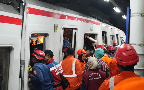 Rettungskräfte suchen nach der Zugkollision noch nach Opfern. - Foto: Ahmad Ibrahim/AP/dpa