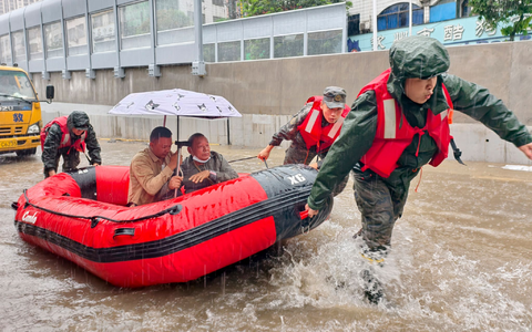 Retter helfen mit Schlauchbooten nach den starken Regenfällen in Qinzhou. - Foto: Ao Shuaichang/X/XinHua/dpa