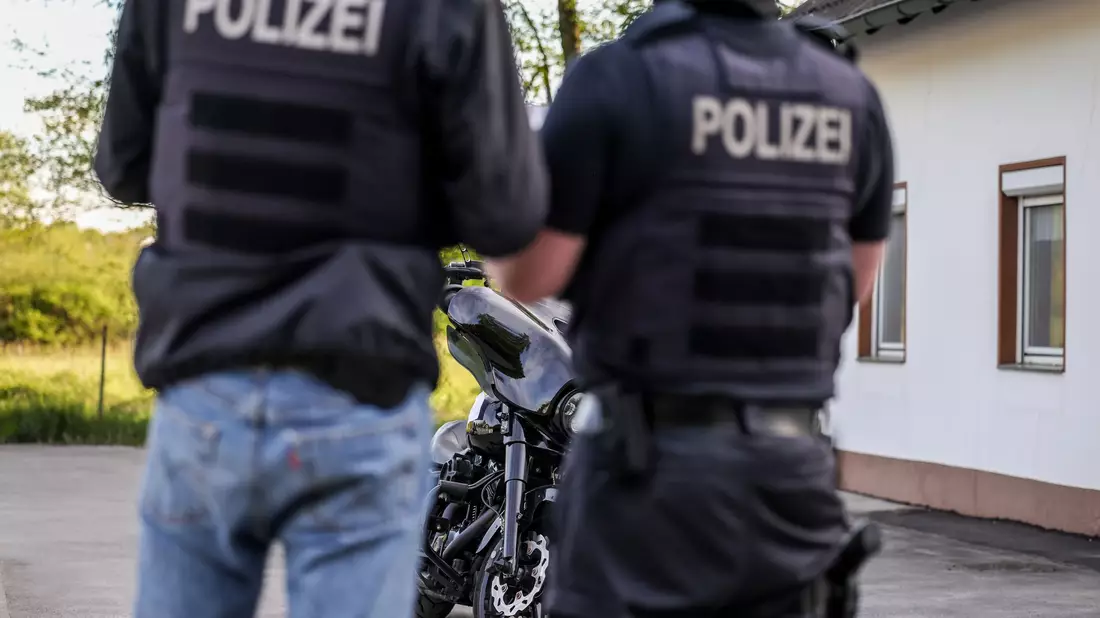 Polizisten beschlagnahmen bei einer Razzia gegen die Rockergruppe «Hells Angels» ein Motorrad.  - Bild: Christoph Reichwein/dpa