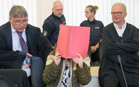 Die Angeklagte sitzt mit Aktendeckel vor dem Gesicht zwischen ihren Verteidigern Andreas Ohm (l-r) und Thomas Löcker.  - Foto: Bernd Wüstneck/dpa