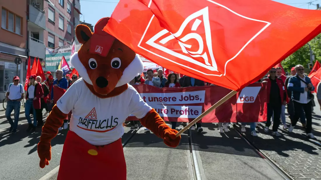 Ein «Tariffuchs» mit IG Metall Fahne bei der zentralen Maikundgebung der Gewerkschaften in Nürnberg.  - Bild: Pia Bayer/dpa