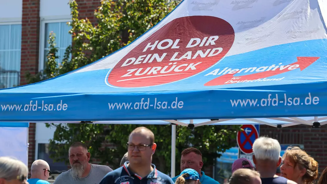 «Hol dir dein Land zurück», steht auf dem Schirm am Stand. Auf den Straßen in Sachsen-Anhalt hat die AfD inzwischen eine Menge Land erobert. - Bild: Peter Gercke/dpa