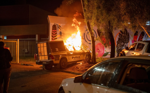 Ein Polizeifahrzeug brennt vor dem Krankenhaus in Alice Springs. - Foto: Rhett Hammerton/AAP Image/AP/dpa