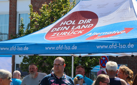 «Hol dir dein Land zurück», steht auf dem Schirm am Stand. Auf den Straßen in Sachsen-Anhalt hat die AfD inzwischen eine Menge Land erobert. - Foto: Peter Gercke/dpa