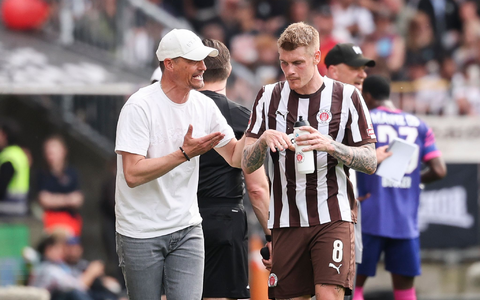 St. Paulis Trainer Alexander Blessin (l) spricht mit Eric Smith. - Foto: Christian Charisius/dpa