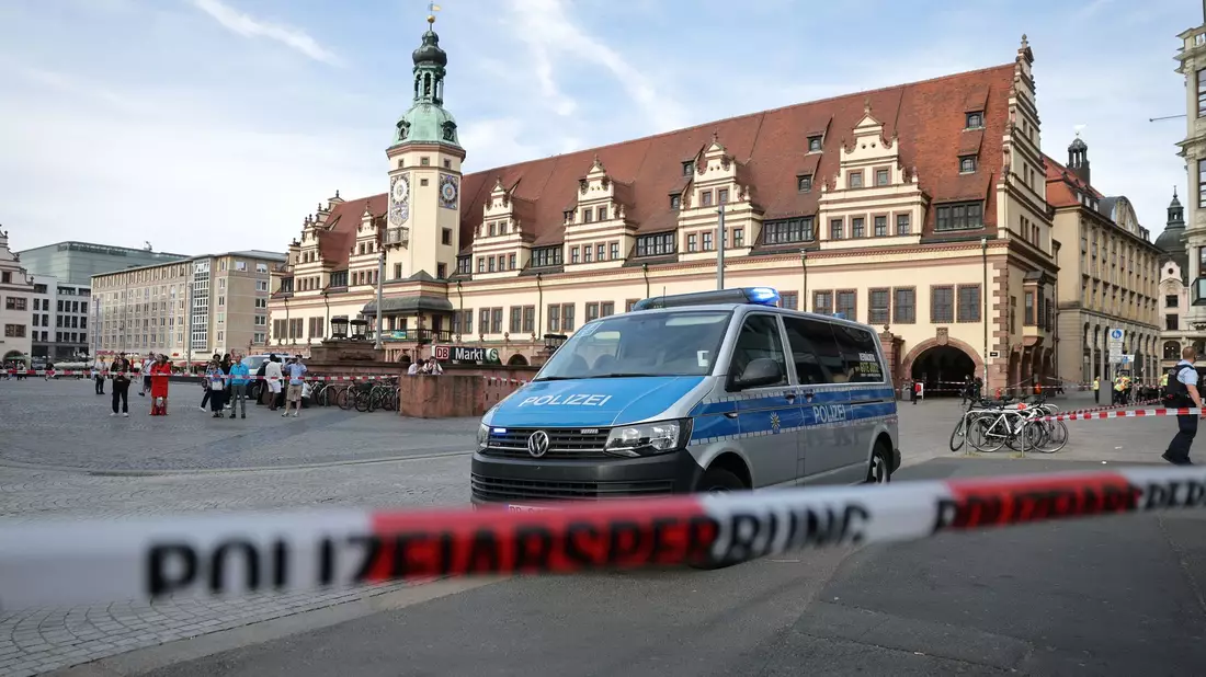 Rettungskräfte stehen in der Nähe eines beschädigten Autos an der Stelle, wo ein Auto in eine Menschengruppe gefahren ist. - Bild: Jan Woitas/dpa