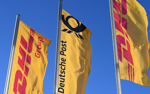 Eine Deutsche-Post-Fahne an der Konzernzentrale, umrahmt von DHL-Fahnen. - Foto: Wolf von Dewitz/dpa