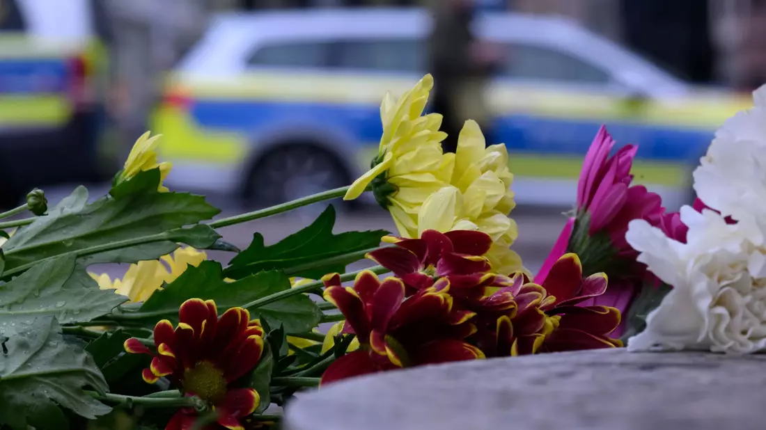 An der Zufahrt zur Grimmaischen Straße wurden Blumen abgelegt.  - Bild: Hendrik Schmidt/dpa