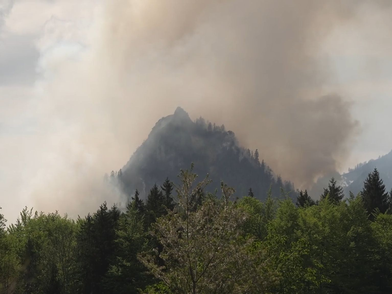Dichter Rauch ist über dem Berg in den bayerischen Alpen zu sehen. - Foto: Gabriel Neumayr/dpa