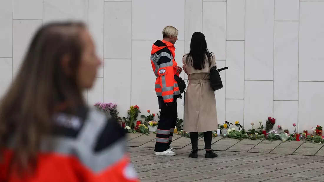 Blumen und Kerzen vor dem Paulinum erinnern an die Opfer der Amokfahrt. - Bild: Jan Woitas/dpa