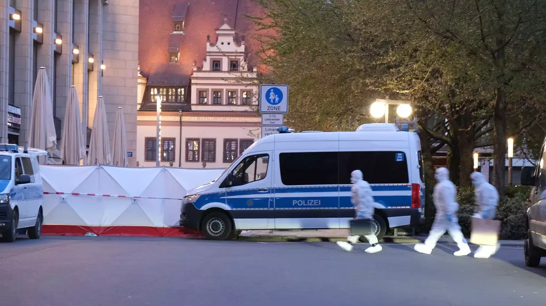 Kriminaltechniker gehen zum Tatfahrzeug.  - Bild: Sebastian Willnow/dpa
