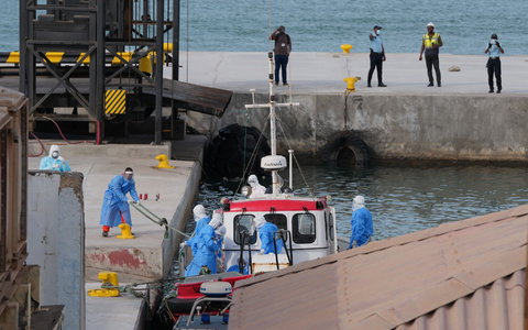 Gesundheitspersonal in Schutzkleidung evakuiert Patienten vom Kreuzfahrtschiff «Hondius» in einem Hafen.  - Foto: Misper Apawu/AP/dpa